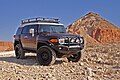 A modified Toyota FJ Cruiser with suspension lift, roof rack, steel bumpers, and mud terrain tires