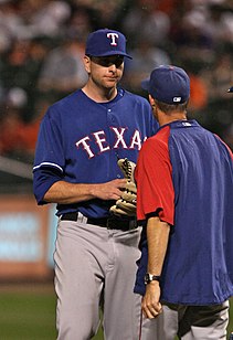 Tall player engaged in a mound conference with shorter man