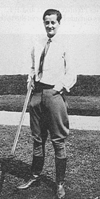 Full length picture of a woman with short hair, standing outdoors and holding a shotgun