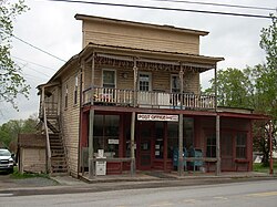 Image of a mildly dilapidated, yellow and red wooden building of a style common in the mid-to-late nineteenth century. A hand-painted sign on the front reads, "POST OFFICE STARRUCCA, PA. 18462."