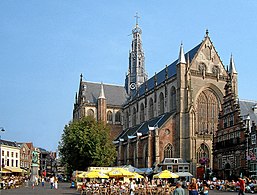 El exterior de la (Grote Kerk) de Haarlem. Los arbotantes han sido suprimidos, pero el gran vitral de la fachada, típicamente brabanzón, está bien presente.