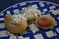 dumplings on a plate, one cut open to show fruit inside, all topped with cottage cheese