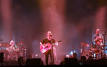 A group playing instruments and singing into microphones