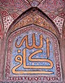 Arabic calligraphy on glazed tile: "God is aplenty".