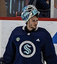 Hockey player in blue Seattle Kraken hockey jersey and helmet