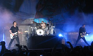 Blink-182 performing in 2011. From left to right: Mark Hoppus, Travis Barker, and Tom DeLonge.