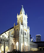 A white, lit up church stands against a night sky