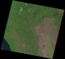 A 1992 satellite image shows a dark brown scar surrounded by forests just after the fire