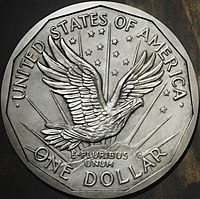 One side of a coin design, depicting an eagle flying above a mountaintop