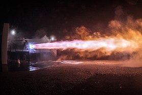 Rocket engine firing with purple-orange flame