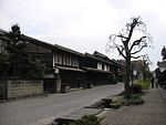 Small street lined by wooden two-storeyed houses.