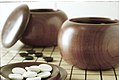 Image 16An example of single-convex stones and Go Seigen bowls. These particular stones are made of Yunzi material, and the bowls of jujube wood. (from Go (game))