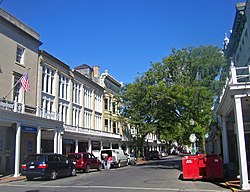 A street with commercial buildings and wooden roofs on the sidewalks