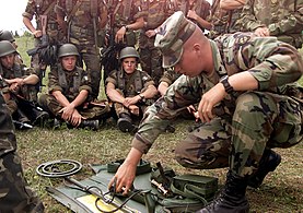 American soldier shows Italian colleagues details of a mine detector during the "Peace Shield" exercise, July 2000