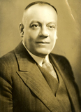 A sepia photo of a man in a suit with a tie.