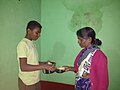 A boy distributing consecrated kosambri - house to house in a south Indian village.