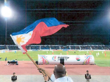 A fan waves the Philippine flag as support for the national team playing against Jordan in the Asian Cup