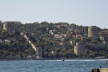 Photograph showing the fortress in the distance, with sea in the foreground