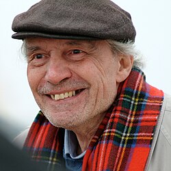 Man in a hat and red scarf smiling