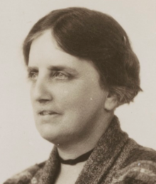 sepia toned headshot photograph of a woman facing left with her hair pinned back.