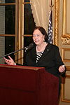 Photographs of a woman standing at a podium and gesturing.