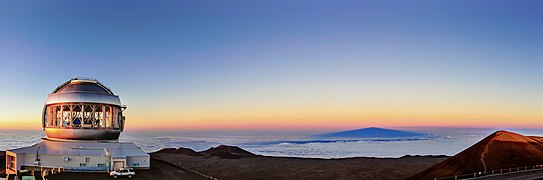 Maunakea’s highest point (far right) is tinged with light from the setting Sun, as shadows fall over Gemini North.[28]