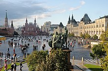 A crowded town square in Moscow with a statue displayed in the center