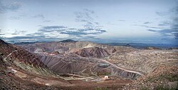 One of the active pits at the Morenci Mine. The horizontal shelves are the mining benches. The fan-like slopes are leached material, dumped into mined-out portions of the pit.