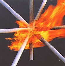 Pipe covered with a thin-film intumescent spray fireproofing commercial product called UniTherm. When the flame from a blow-torch is applied, the intumescent sodium silicate expands, forming a layer of insulation which slows heat transfer to the pipe underneath. Hydrates within the coating release their water content, maintaining a temperature near the boiling point of water, 100 °C. The critical steel temperature is ca. 540 °C. Once the water is consumed and sufficient heat has passed through the char, the steel can reach and exceed its critical temperature and lose its strength. The time this takes determines the fire-resistance rating.