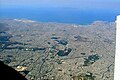 Aerial view of portions of central Athens, the port of Piraeus, and some of the city's southern suburbs. The Saronic Gulf lies in the background.