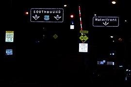 At night, the retroreflective buttons on these overhead signs in Seattle, Washington are often lit up by light sources (such as a vehicle's headlamps) to ensure easier reading