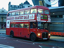 Red two-storey vehicle with windows on each level.