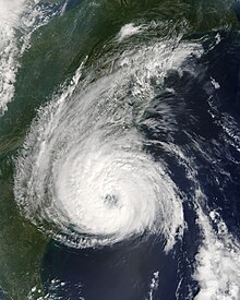 A satellite image of a well-organized hurricane featuring a circular area of clouds with a partially cleared eye in the middle.