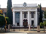 White building with the inscription Navy school of mechanics in Spanish