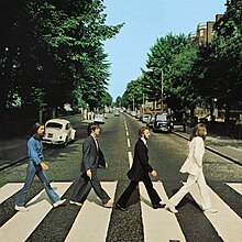 The cover of Abbey Road has no printed words. It is a photo of the Beatles, in side view, crossing the street in single file.