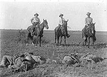 Capt. Monroe Fox and two other Rangers on horseback with their lariats around the bodies of dead Mexican bandits, after the Norias Ranch Raid on August 8, 1915