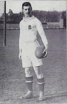 A black and white photo of a man holding a rugby ball