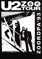 A black poster with a black-and-white image occupying most it. The image shows U2 walking up the stairs of a small aeroplane as Bono gives a peace sign towards the viewer. Text on the poster reads "U2 Zoo TV Tour" and "Zooropa '93".