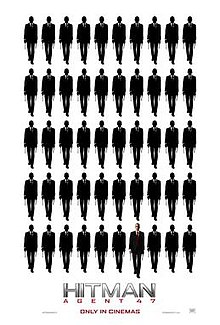 Five rows of ten indistinct figures. The forty-seventh figure is bald, wearing a suit with a white shirt and red tie.