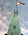 The Queen's Personal Canadian Flag, featuring the Royal Banner of Scotland in the quartered coat contained in the first and second divisions, flying over the Peace Tower, Ottawa.