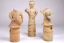 Three clay figures called haniwa, two of which depict figures playing drums.